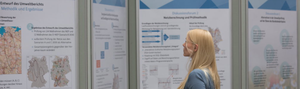 Teilnehmerin einer Veranstaltung betrachtet Poster zum Umweltbericht Teilnehmerin einer Veranstaltung betrachtet Poster zum Umweltbericht